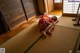 A woman in a kimono laying on the floor in a room.