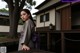 A woman in a kimono standing in front of a building.