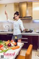 A woman standing in a kitchen holding a spatula.