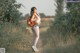 A woman with a backpack walking down a dirt road.