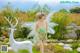 A woman in a green dress standing next to a white deer.