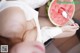 A woman eating a slice of watermelon with a spoon.