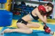 A woman in a black bikini and red boxing gloves.