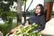 A woman sitting on a bench next to a tree.