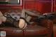 A woman laying on a brown leather couch wearing black stockings.